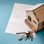 Keys, a home miniature, and papers for the analysis of the future of commercial real estate in Tampa